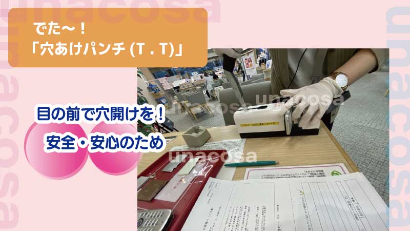 ガラケーに穴あけパンチをしている画像